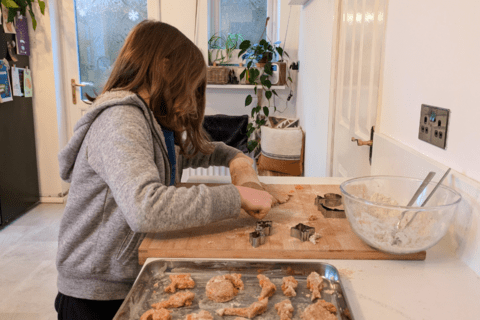 A child using a cookie cutter to shape pet treats