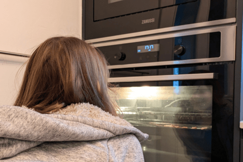 A child watching treats bake in the oven
