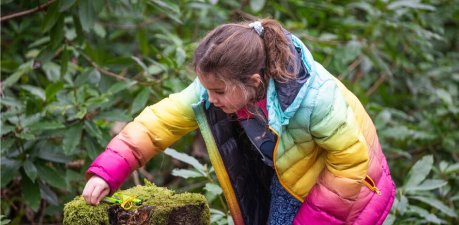 A young girl in a rainbow jacket