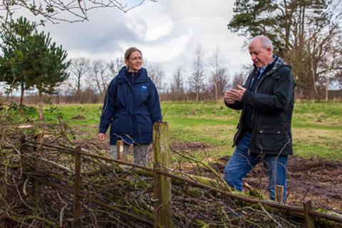 Garden designer Martyn Wilson designer looking at a dead hedge which encourages wildlife