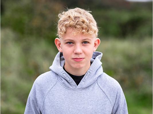 A young boy, looking directly at the camera