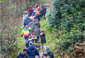 A group of children walking in a line in the forest