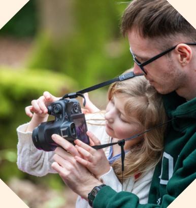 A young girl and her father taking pictures