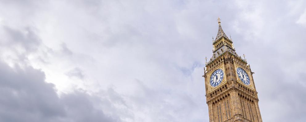 Photo of Big Ben in London sitting among clouds.