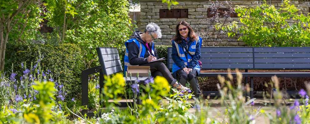 Two people from the RSPCA doing paperwork outdoors.