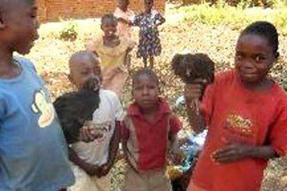 A group of African children holding monkeys.