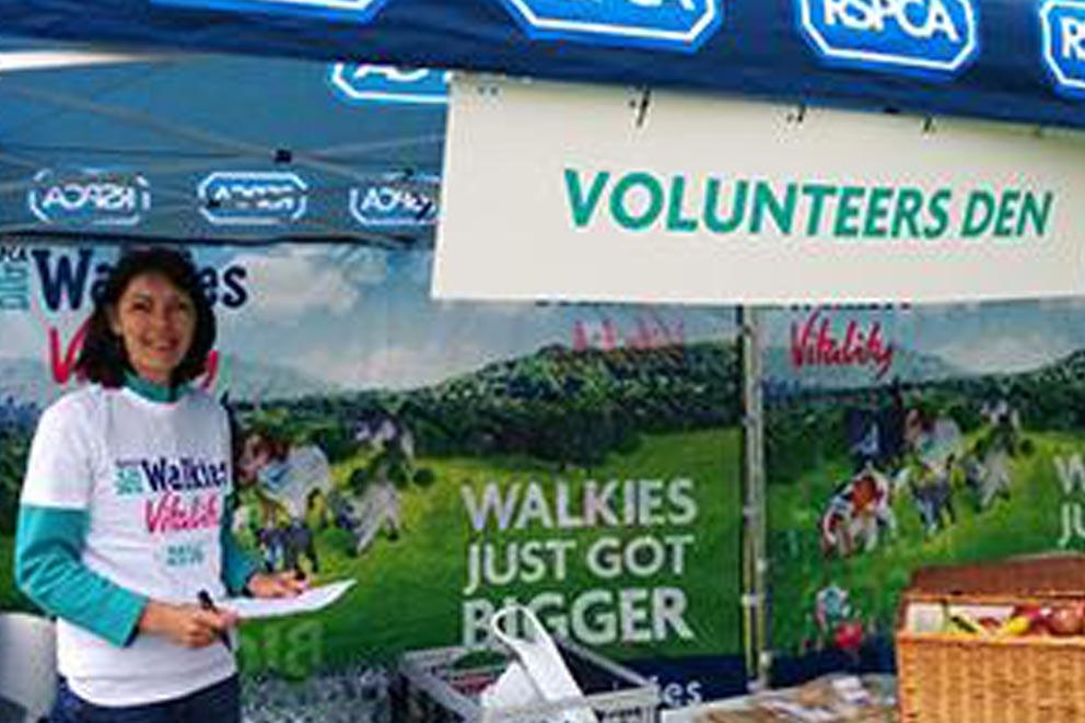 Debbie Gadd standing by a Volunteers stand at an RSPCA themed event.