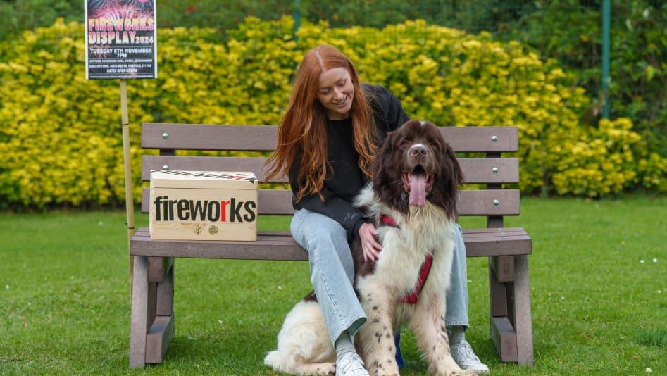 Woman and dog sat on a bench