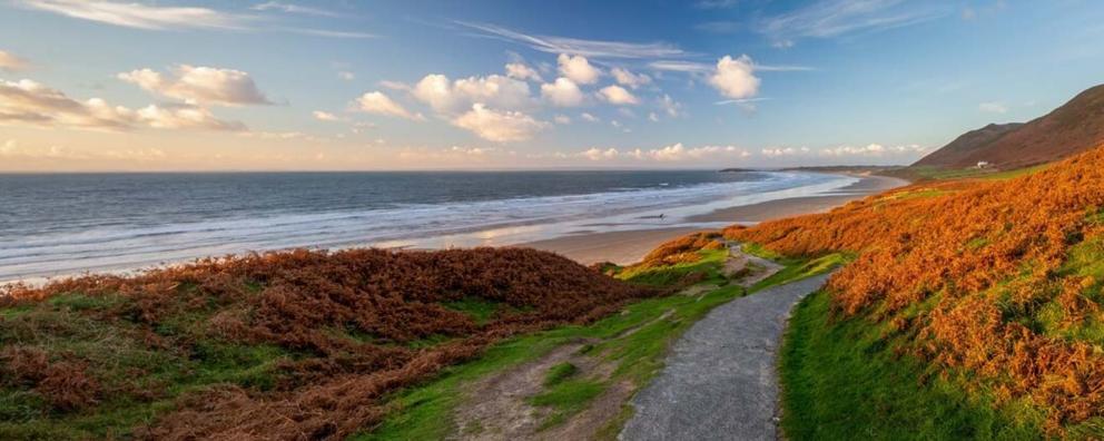 A panoramic view of a beach along the Gower peninsular in Wales.