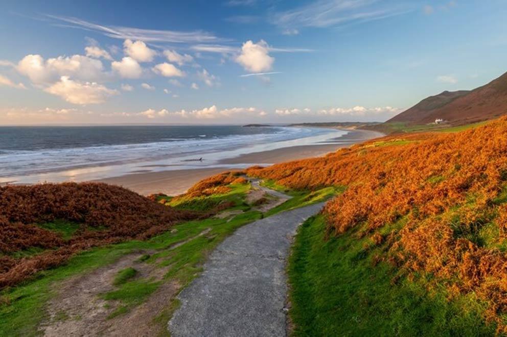 A panoramic view of a beach along the Gower peninsular in Wales.