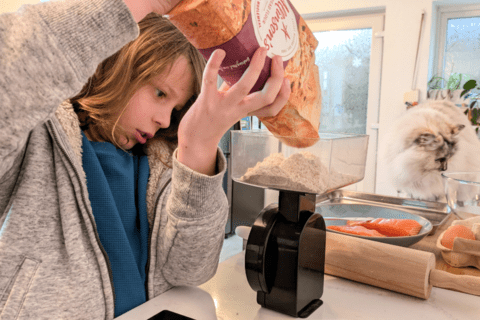 Young person weighing whole wheat flour in the kitchen.